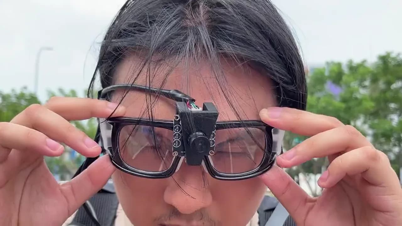 A RunSight wearer adjusts the prototype camera glasses on a running track